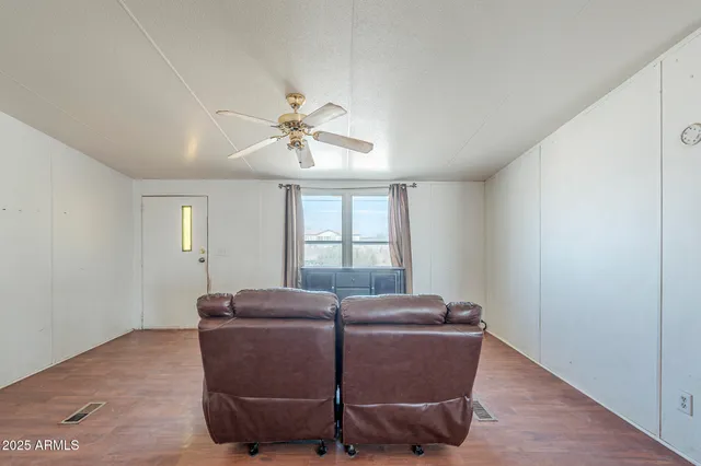 a living room with furniture window and a ceiling fan