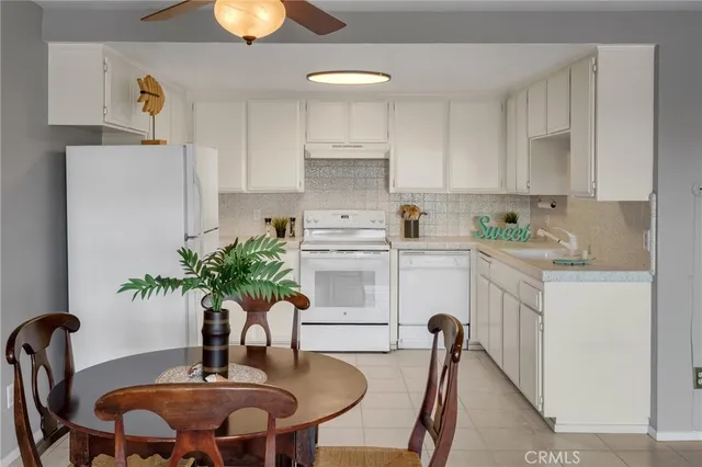 a kitchen with stainless steel appliances a table and chairs in it