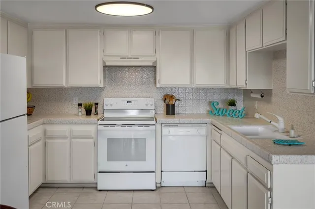 a kitchen with cabinets appliances a sink and a counter space