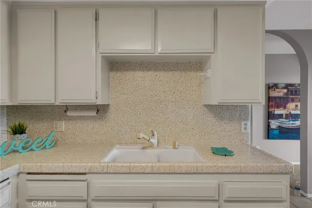 a kitchen with white cabinets and a sink