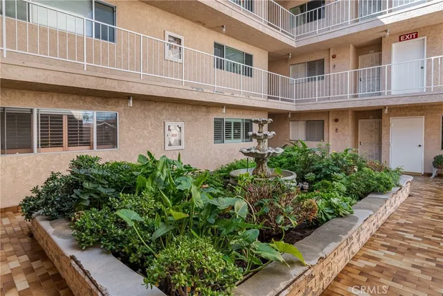 a front view of a building with plants and trees