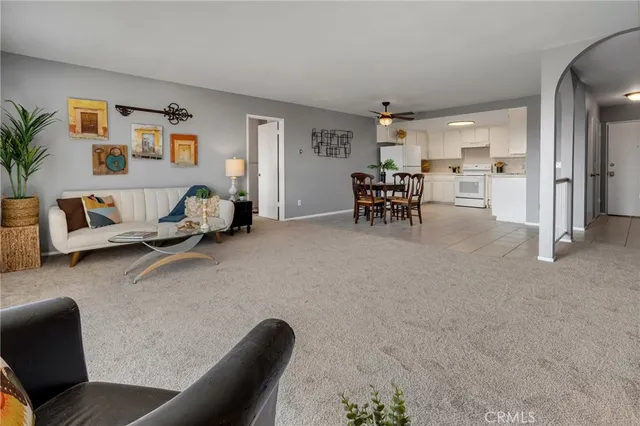 a living room with furniture and a dining table with kitchen view