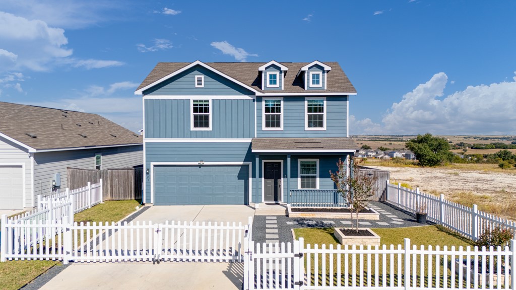 205 Rooster Way Jarrell, TX 76537 - Photo 1 of 29 Traditional home with covered porch, driveway, an attached garage, roof with shingles, and a gate