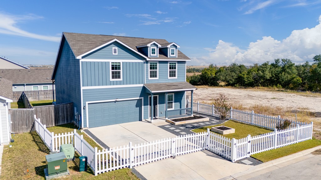 205 Rooster Way Jarrell, TX 76537 - Photo 26 of 29 Traditional-style home featuring driveway, a fenced front yard, an attached garage, board and batten siding, and a gate