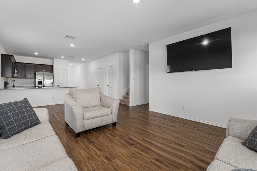205 Rooster Way Jarrell, TX 76537 - Photo 7 of 29 Living area featuring dark wood-type flooring, recessed lighting, and stairway