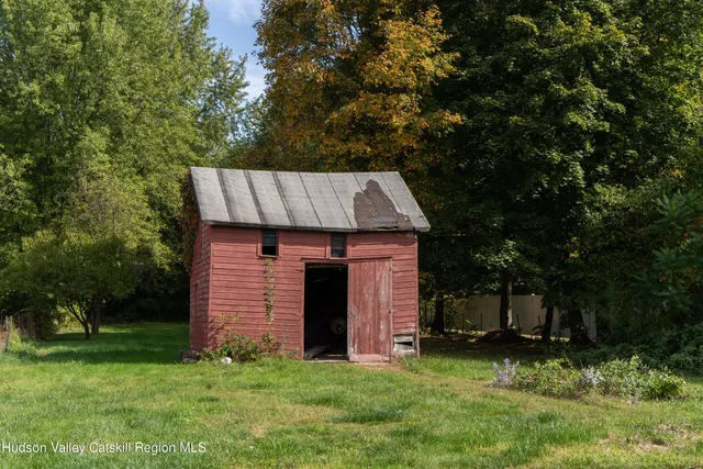a view of a wooden house with a small yard