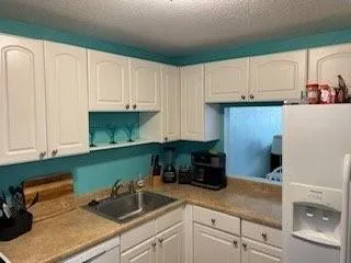 a view of a white house next to a yard