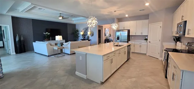 a large white kitchen with a large counter top appliances and cabinets