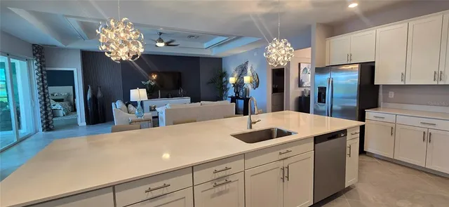 a kitchen with a sink dishwasher and a chandelier