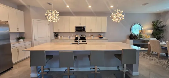 a view of a dining room with furniture a chandelier and wooden floor