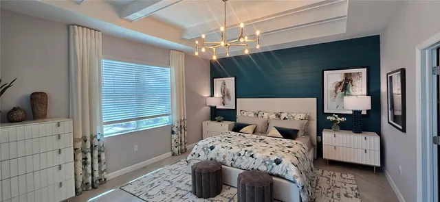 a bedroom with a bed a couch and chandelier