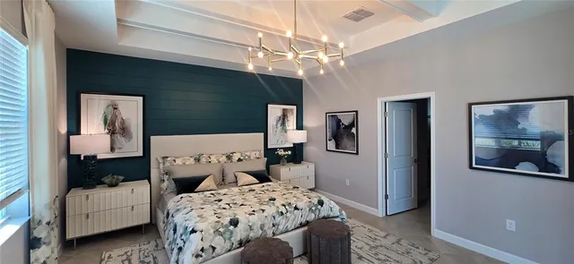 a bedroom with bed and a chandelier