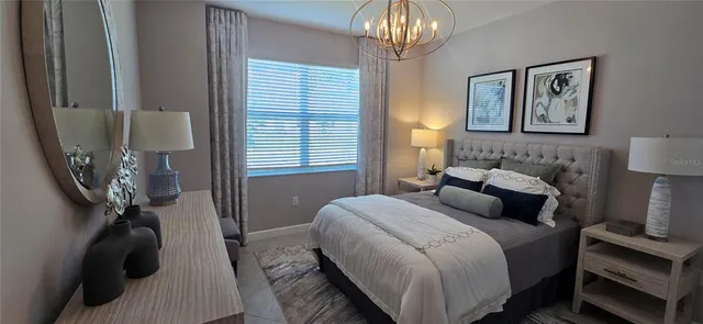 a bedroom with a bed and a chandelier