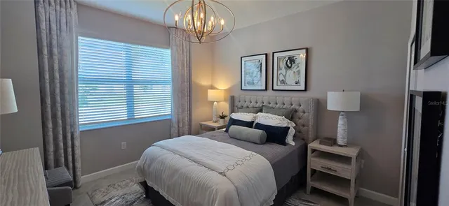 a bedroom with a bed and a chandelier