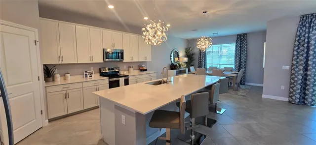 a kitchen with a table chairs sink and cabinets