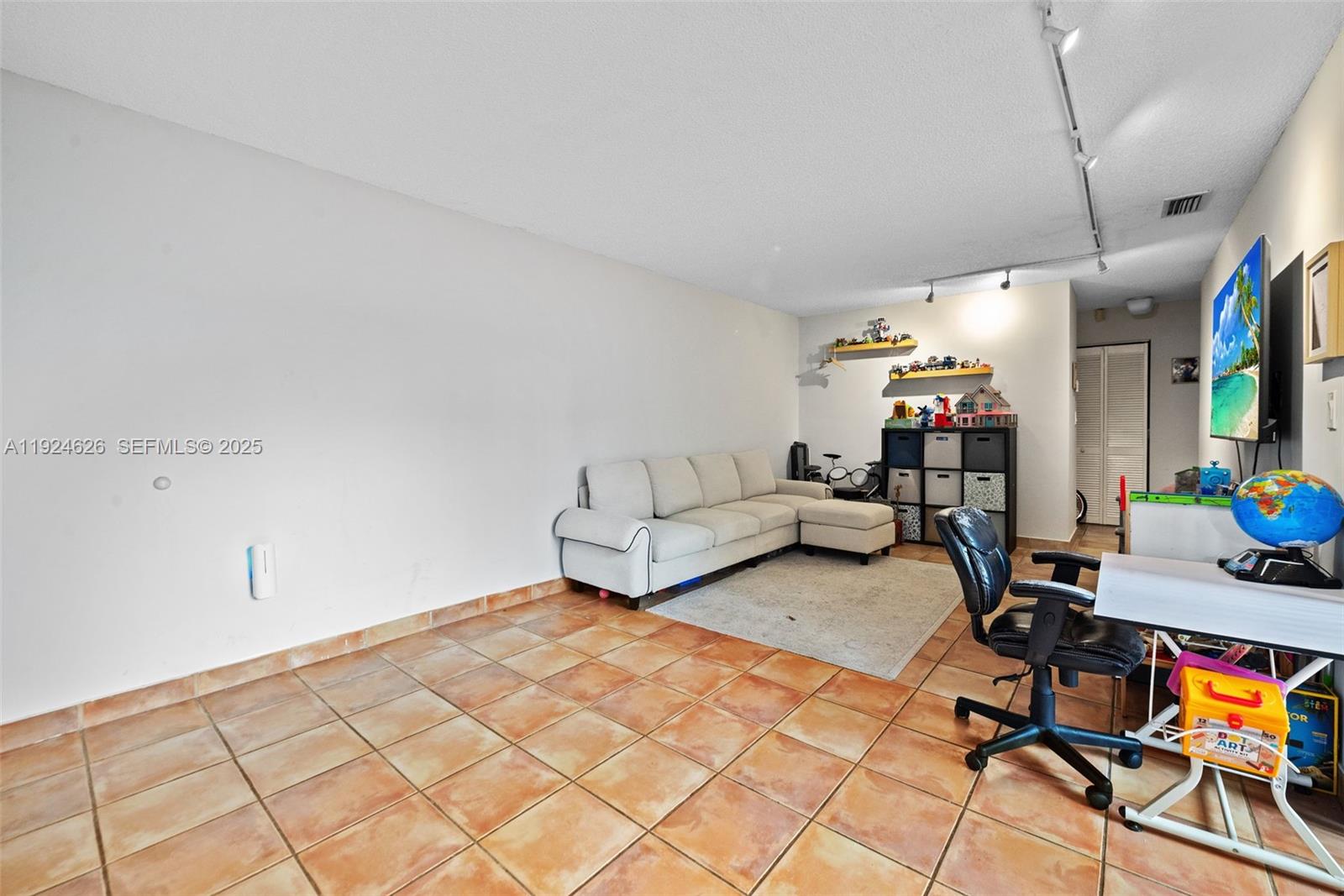 11840 Southwest 80th Street, Unit 526 Miami, FL 33183 - Photo 14 of 25 a living room with furniture and a flat screen tv
