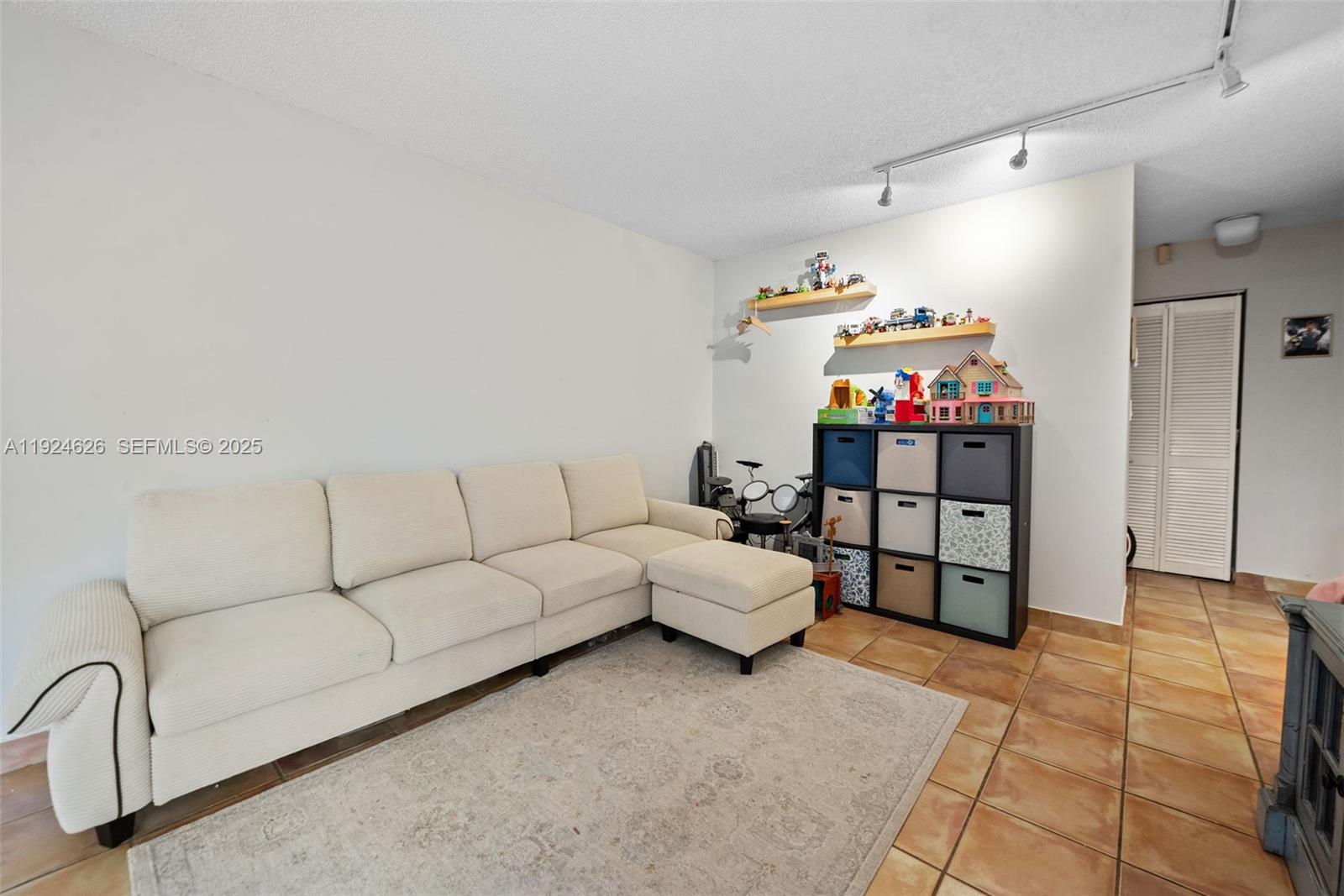 11840 Southwest 80th Street, Unit 526 Miami, FL 33183 - Photo 15 of 25 a living room with furniture and a flat screen tv