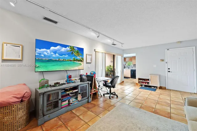 a living room with furniture a flat screen tv and floor to ceiling window
