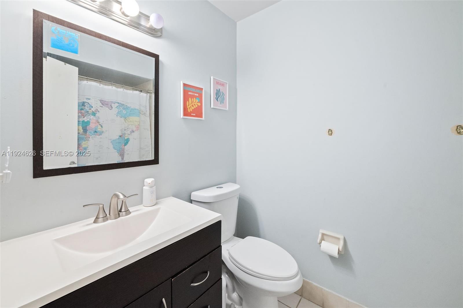 11840 Southwest 80th Street, Unit 526 Miami, FL 33183 - Photo 20 of 25 a bathroom with a toilet a sink and mirror
