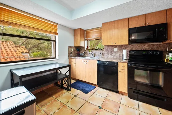 a kitchen with stainless steel appliances a stove a sink and a microwave