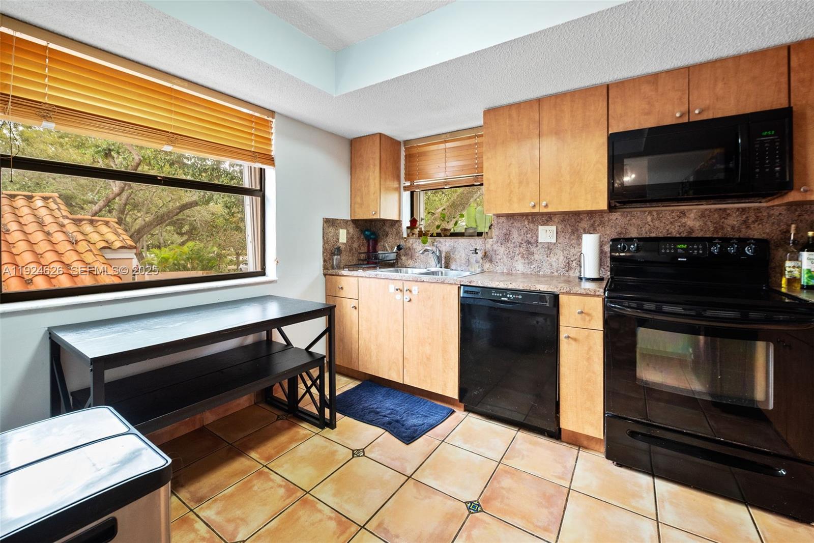 11840 Southwest 80th Street, Unit 526 Miami, FL 33183 - Photo 4 of 25 a kitchen with stainless steel appliances a stove a sink and a microwave