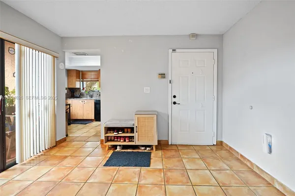 a hallway with a black white checkered floor with a rug
