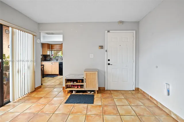 a hallway with a black white checkered floor with a rug