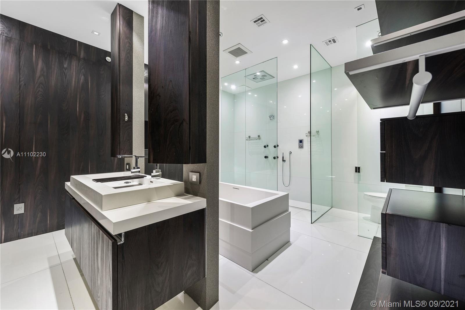 900 Brickell Key Boulevard, Unit 2902 Miami, FL 33131 - Photo 15 of 32 a bathroom with a sink a mirror and a shower