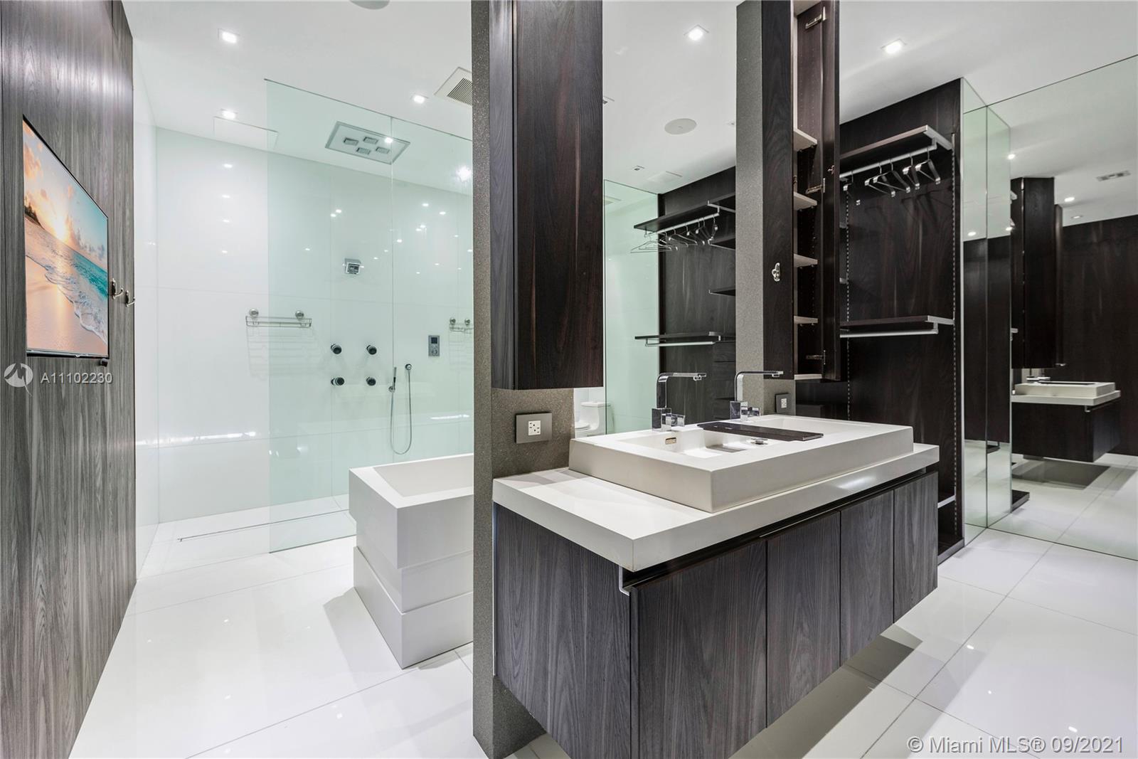 900 Brickell Key Boulevard, Unit 2902 Miami, FL 33131 - Photo 16 of 32 a bathroom with a sink a toilet a mirror and shower