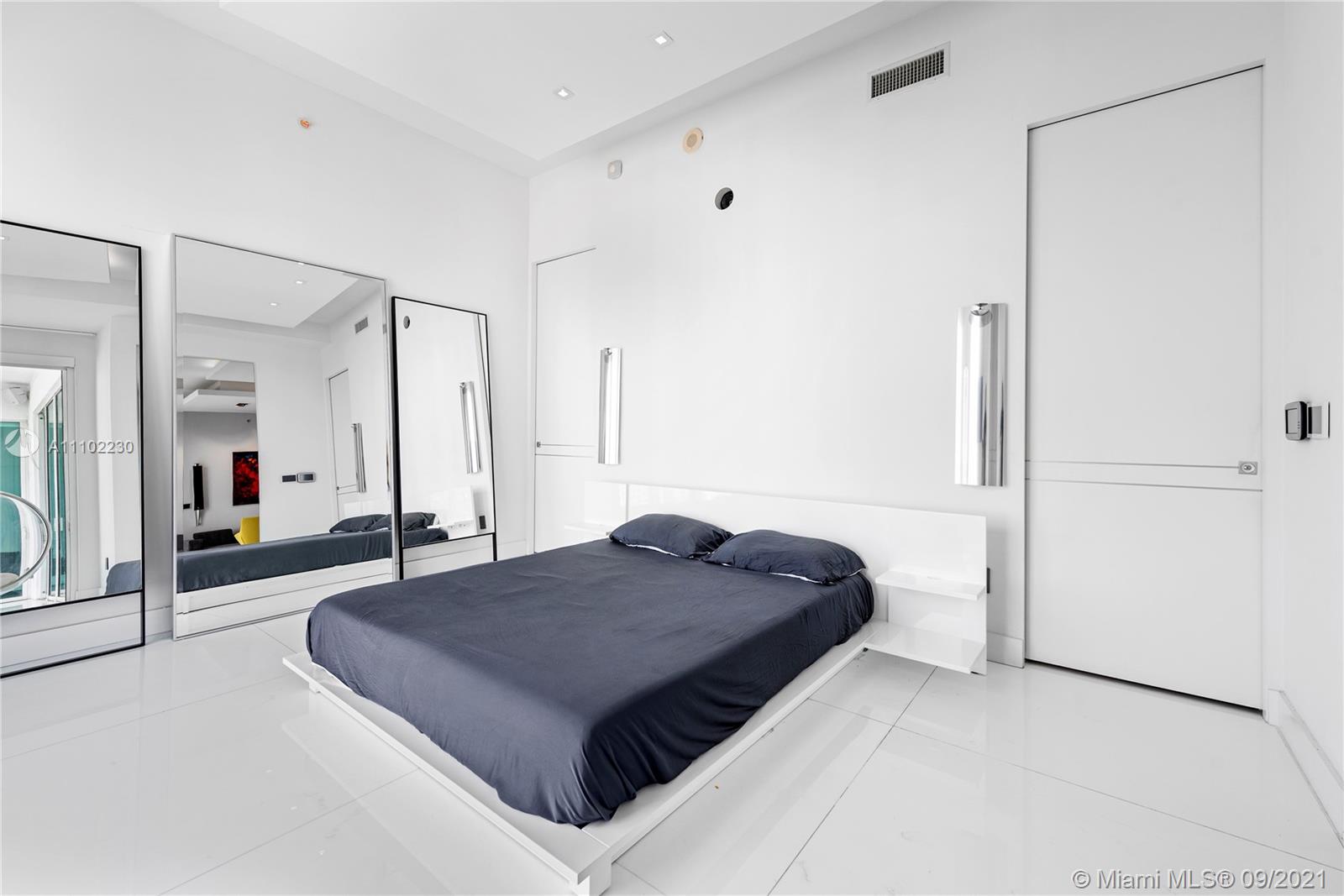 900 Brickell Key Boulevard, Unit 2902 Miami, FL 33131 - Photo 23 of 32 a spacious bedroom with a bed and glass door