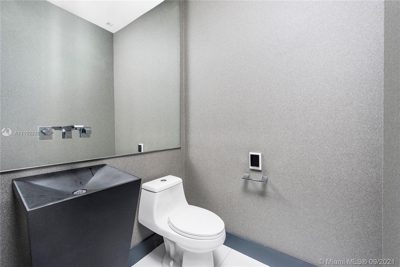 900 Brickell Key Boulevard, Unit 2902 Miami, FL 33131 - Photo 26 of 32 a white toilet sitting next to a bathroom sink
