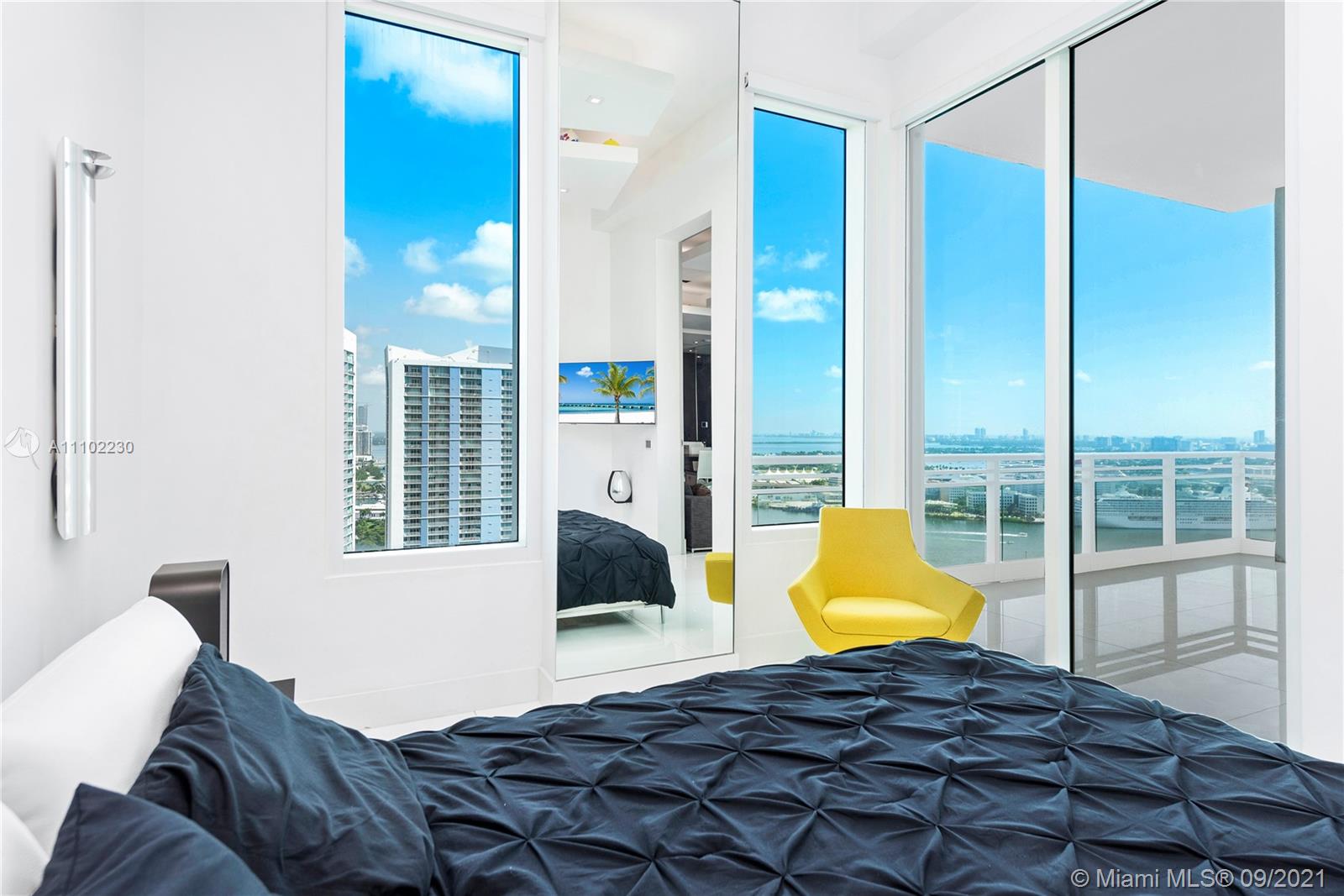 900 Brickell Key Boulevard, Unit 2902 Miami, FL 33131 - Photo 9 of 32 a bedroom with a bed and wooden floor