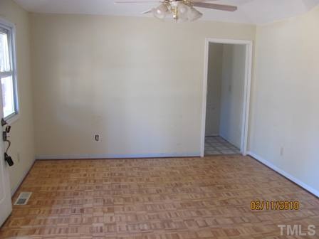 8517 Ray Road Raleigh, NC 27613 - Photo 4 of 5 an empty room with a chandelier fan