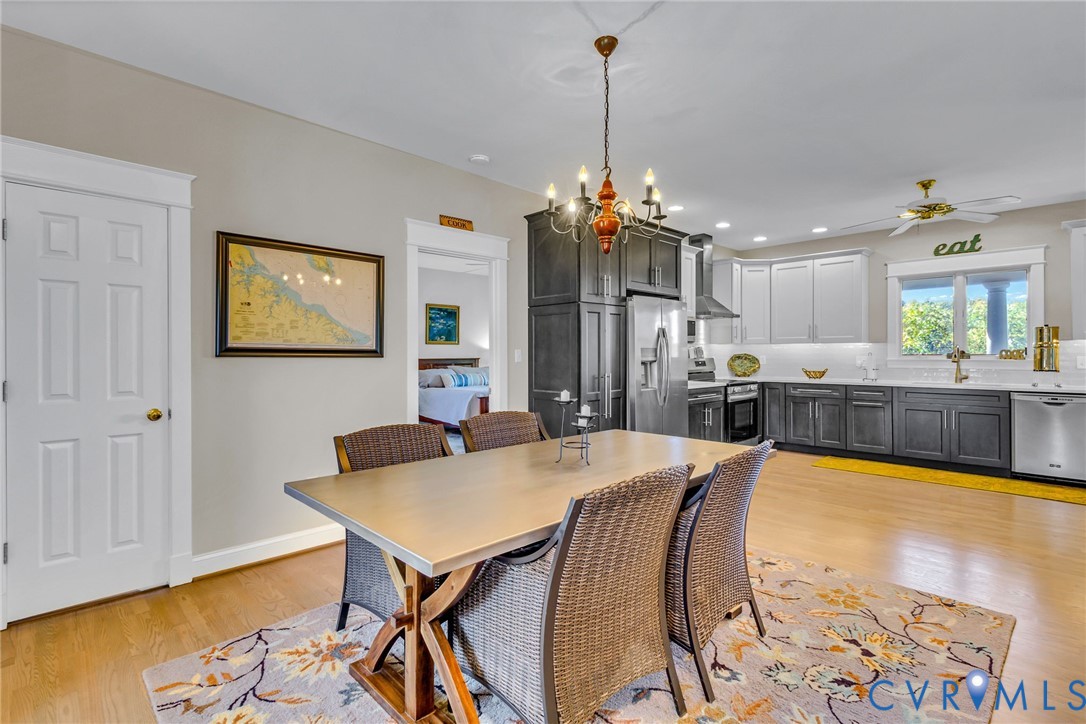 1248 Bancton Road Kinsale, VA 22488 - Photo 3 of 50 a view of a dining room and livingroom with furniture wooden floor a rug a flat screen tv a painting and a chandelier