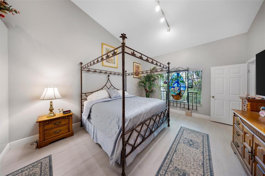 4115 Carriage Drive, Unit P2 Pompano Beach, FL 33069 - Photo 13 of 21 a bedroom with bed and a chandelier