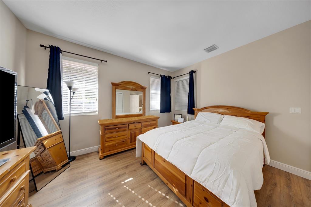 4115 Carriage Drive, Unit P2 Pompano Beach, FL 33069 - Photo 19 of 21 a bedroom with a bed and wooden floor