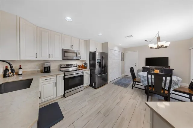 a kitchen with a table chairs microwave and refrigerator