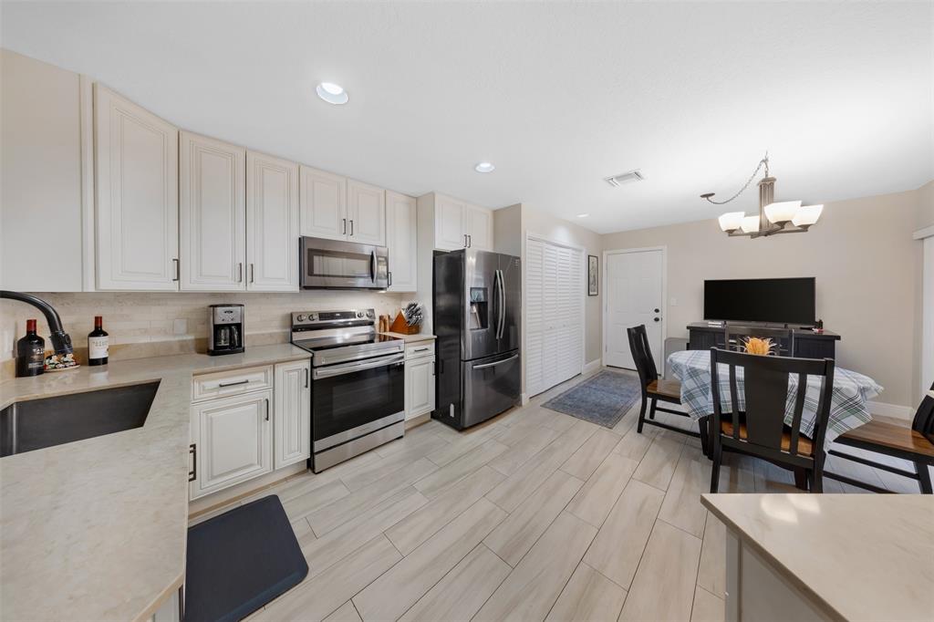 4115 Carriage Drive, Unit P2 Pompano Beach, FL 33069 - Photo 7 of 21 a kitchen with a table chairs microwave and refrigerator
