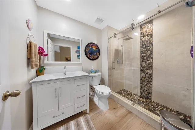 a bedroom with a bed a couch and a potted plant on the table