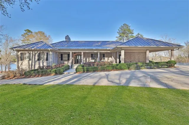 a front view of a house with a yard and potted plants