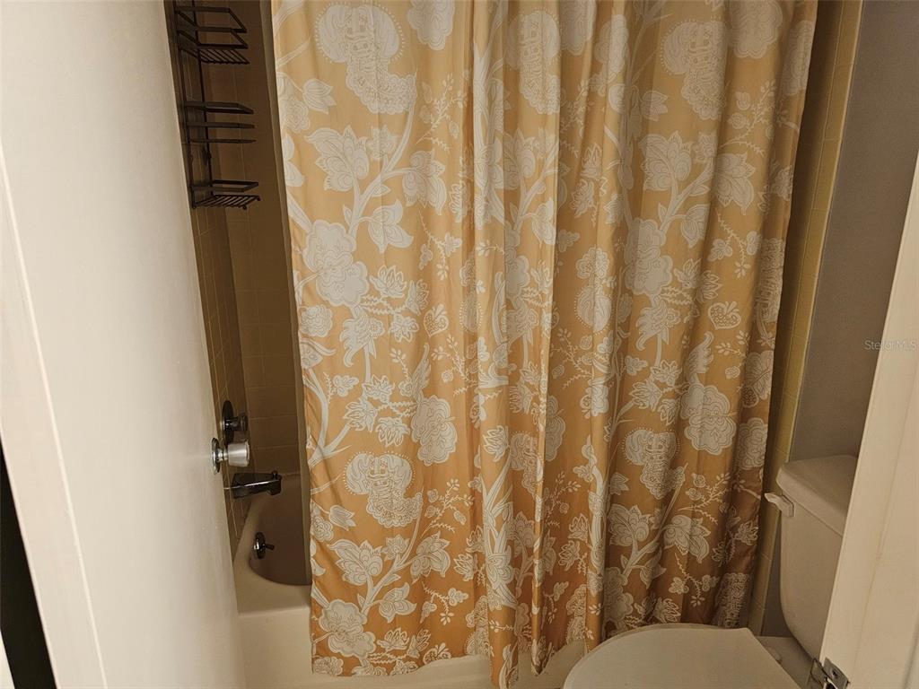 4119 61st Ave Terrace West, Unit 303 Bradenton, FL 34210 - Photo 12 of 22 a bathroom with a toilet and shower curtain