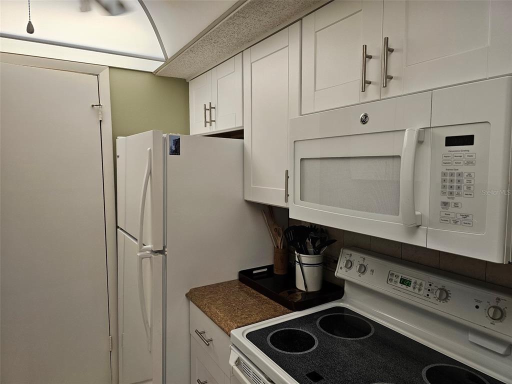 4119 61st Ave Terrace West, Unit 303 Bradenton, FL 34210 - Photo 7 of 22 a kitchen with stainless steel appliances cabinets and a counter top space