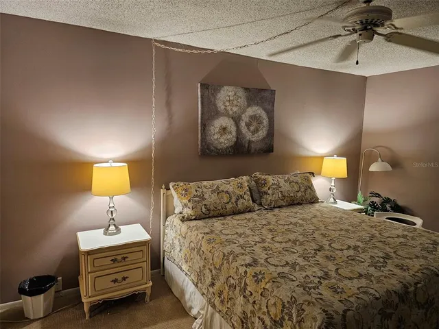 a bedroom with a bed and a lamp on dresser