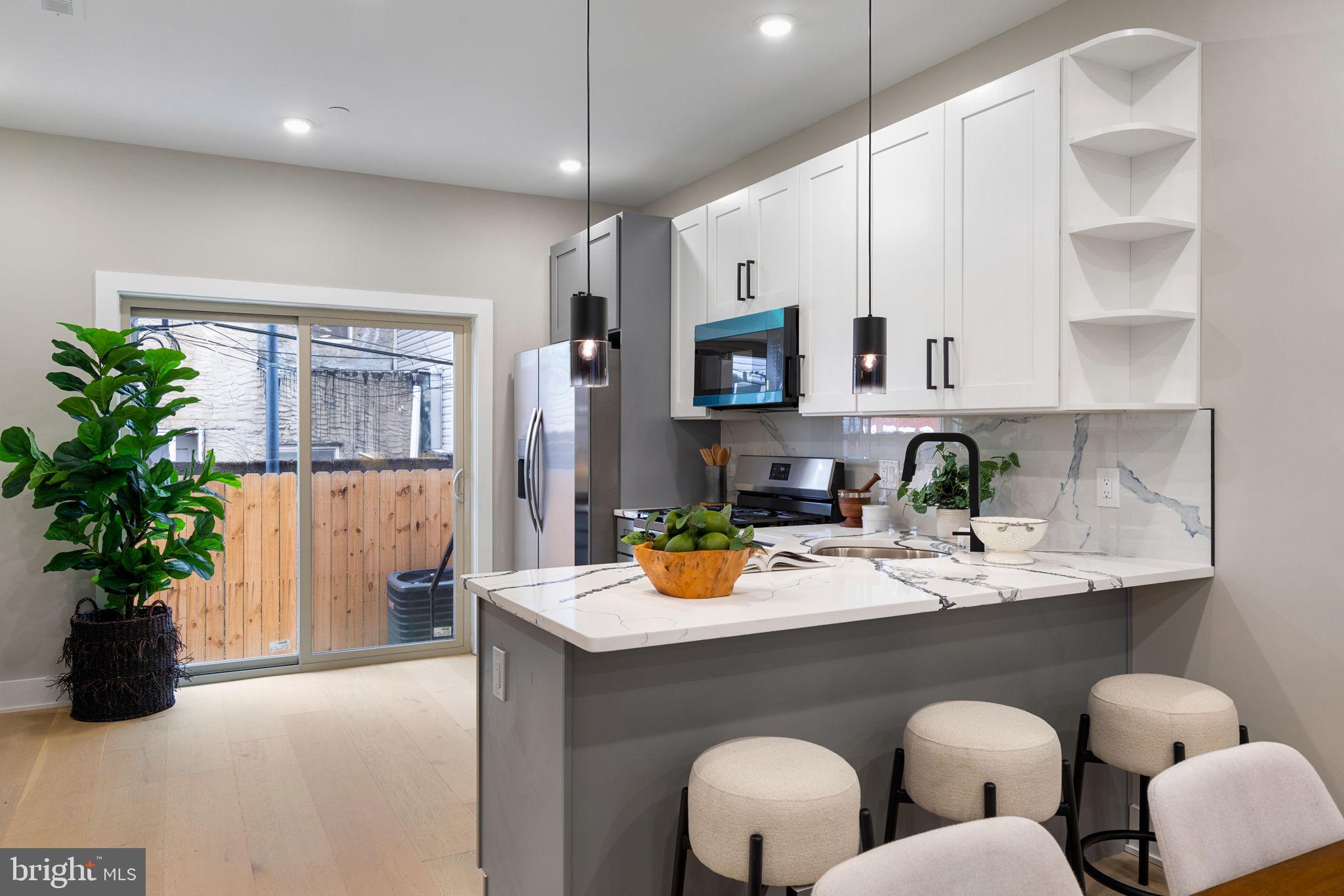 717 Mercy Street Philadelphia, PA 19148 - Photo 13 of 48 a kitchen with white cabinets and center island