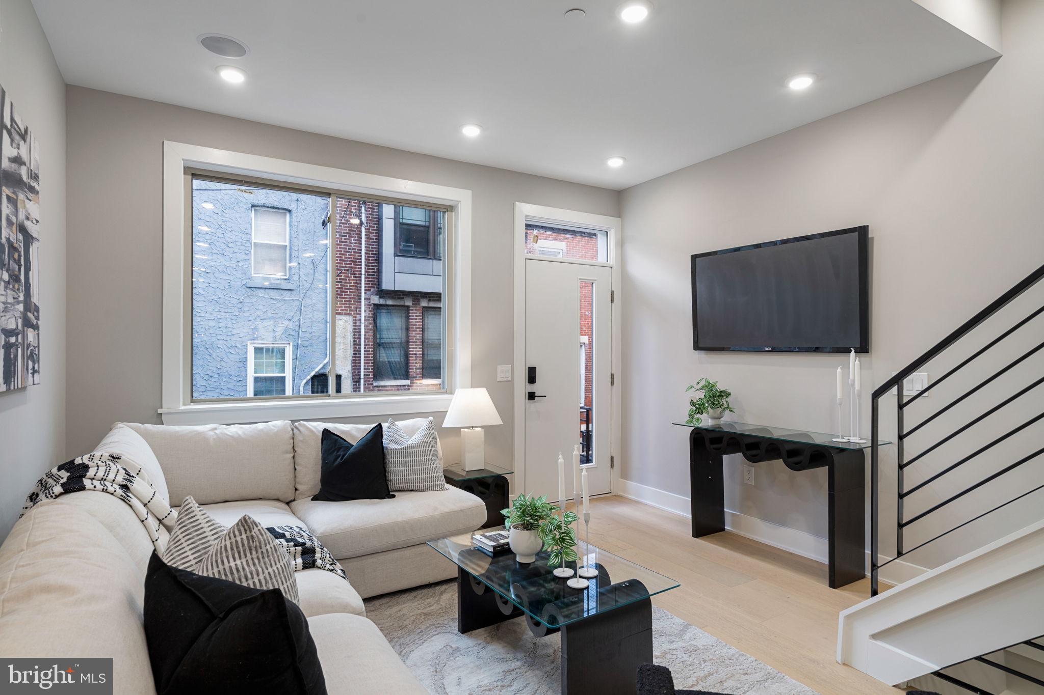 717 Mercy Street Philadelphia, PA 19148 - Photo 5 of 48 a living room with furniture a flat screen tv and a chandelier