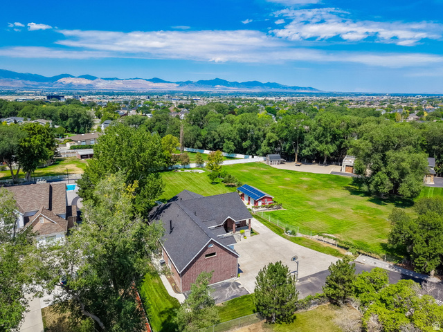 13658 South Fort Street Draper, UT 84020 - Photo 50 of 87 Expansive property featuring a brick exterior residence with a dark shingle roof, a large paved driveway, and a substantial green lawn