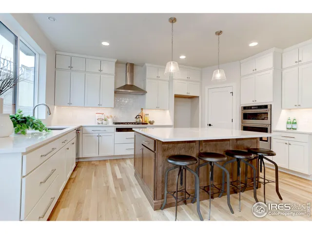 a kitchen with kitchen island granite countertop wooden floors and center island