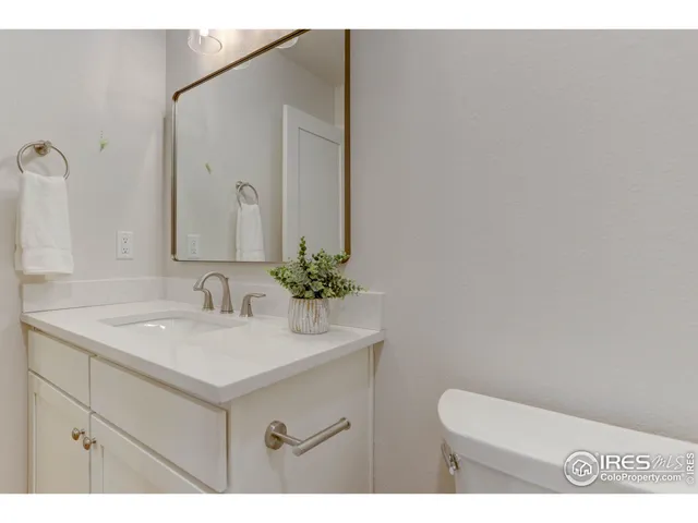 a bathroom with a sink vanity granite and toilet