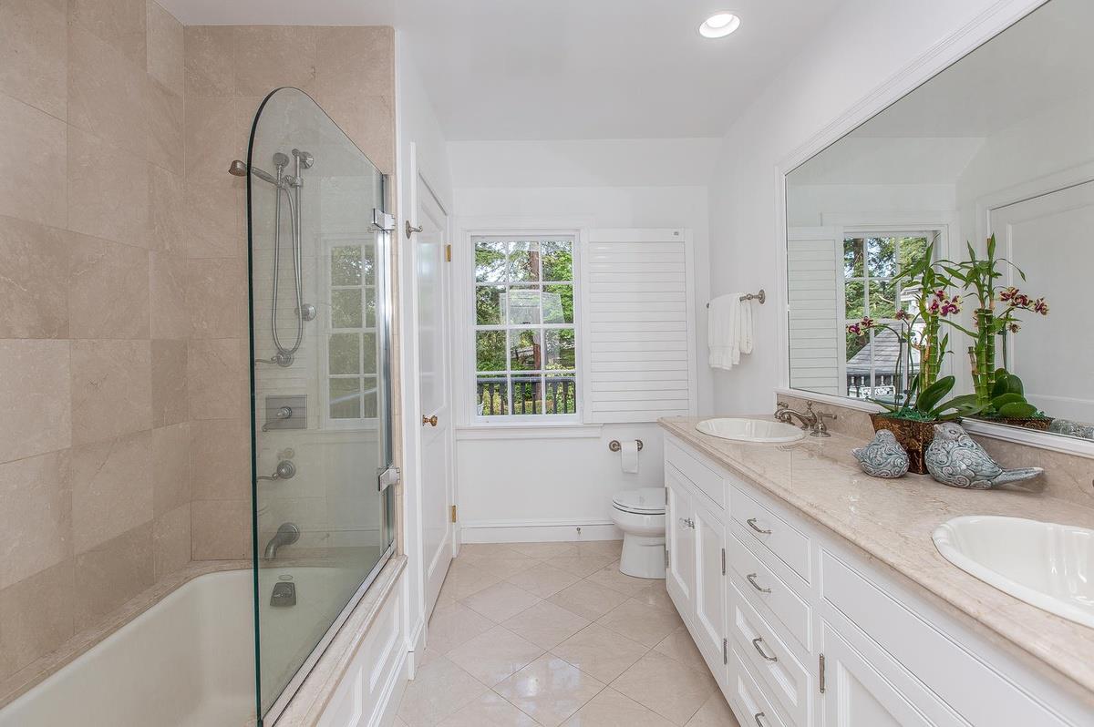 863 Chiltern Road Hillsborough, CA 94010 - Photo 31 of 50 a bathroom with a granite countertop sink a large mirror a bathtub and next to a window