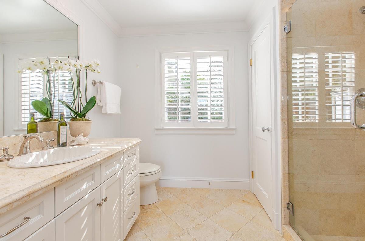 863 Chiltern Road Hillsborough, CA 94010 - Photo 33 of 50 a bathroom with a granite countertop sink a large mirror a and a window
